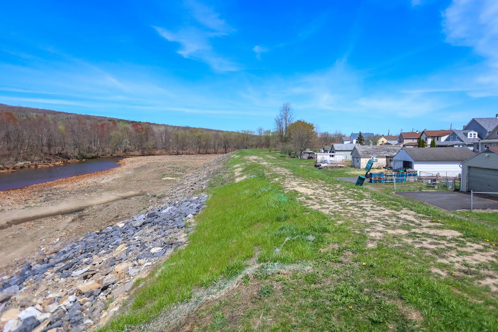 View of small embankment between body of water and houses