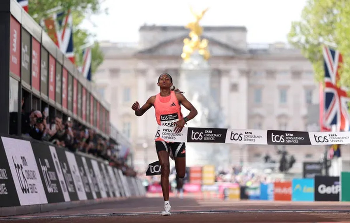 A woman breaks through the tape at the finish line of the TCS London Marathon.