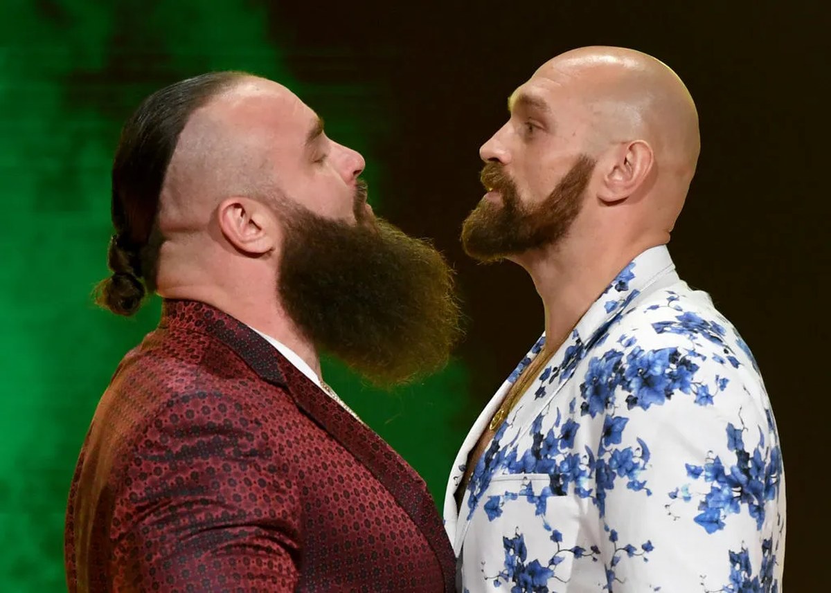 Two muscular men with beards face off.